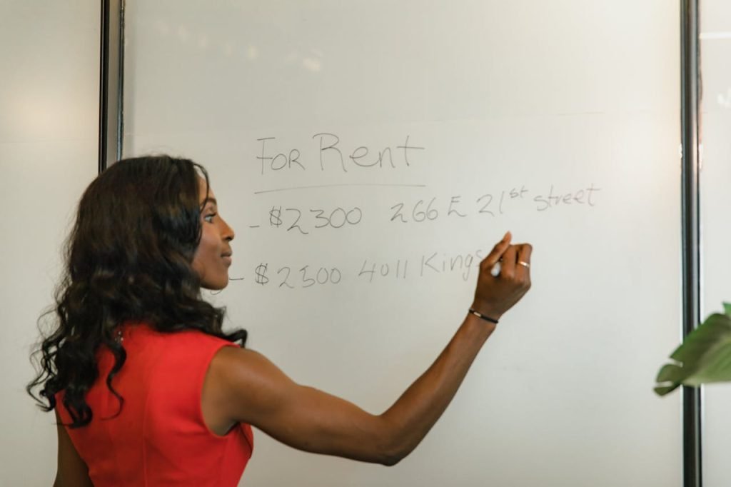 Crafting Captivating Headlines: Your awesome post title goes here Professional woman writing real estate prices on a whiteboard for rental properties.
